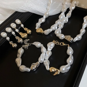 Vue détaillée d'une parure en perles baroques avec collier et boucles sur tissu de soie