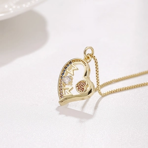 Macro shot of gold MOM heart pendant with pave cubic zirconia and fine gold chain