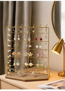 Detail of gold jewelry stand with earring hooks and a hexagonal wooden storage base