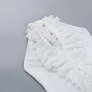 Detailed close-up of white ruffled halter top with sheer mesh fabric and pearl button