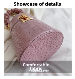 Detail shot of purple crocodile pattern bucket bag with gold chain and scrunched handle