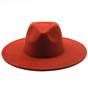 Detailed view of red wool felt fedora with wide brim and flat top on white background
