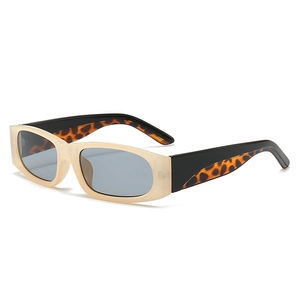 Occhiali da sole rétro con montatura crema e stanghette leopardate su sfondo bianco