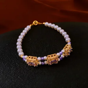 French vintage style pearl bracelet with purple zircon pendants on black background