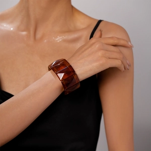 Detail of vintage amber acrylic geometric wide bangle bracelet worn on wrist