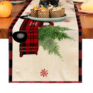 Detail of Christmas table runner featuring red truck, green trees and red snowflake pattern