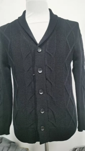 Detailaufnahme der Strickstruktur und Knopfleiste des schwarzen Herren-Cardigans