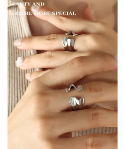 Detailed close-up of wavy liquid metal silver ring with irregular flowing design lines