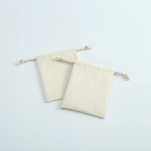 Close-up of two natural cotton canvas drawstring pouches showing textured fabric