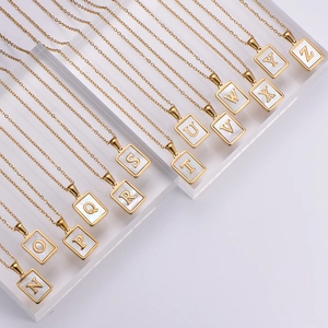 Macro view of 18k gold plated square initial pendants with white shell inlay N to Z