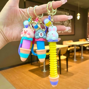Cartoon animal stress relief keychain with retractable tube shown in hand for pig and rabbit