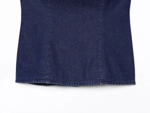Vue détaillée de la texture du denim bleu foncé et des coutures précises sur le vêtement