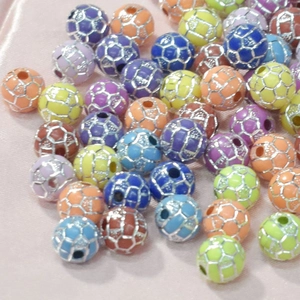 Gros plan de perles de sport en acrylique colorées sur soie rose pour bijoux artisanaux
