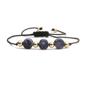 Close-up of adjustable black woven rope bracelet with blue stone beads and gold metal accents