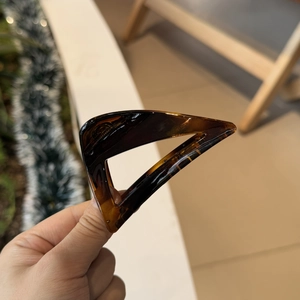 Close-up of tortoise shell triangle hair claw clip with amber acrylic pattern details