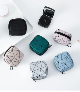Flat lay of small geometric makeup bags in six colors with round metal zipper pulls