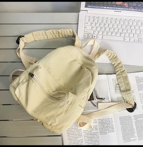 Mini-Leinenrucksack in Beige mit breiten Trägern neben einem Laptop auf einem Holztisch