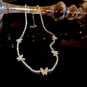 Macro shot of sparkling crystal butterfly pendant on a gold luxury choker necklace