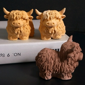 Detailed relief textures of highland cow resin art sculptures on a book stand
