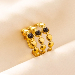 Detail of gold-plated triple-layered ring with black marble stone inlay in macro view