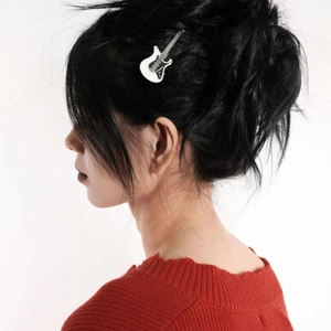 Close-up of a white electric guitar hair clip worn on a side bun for a Y2K aesthetic look