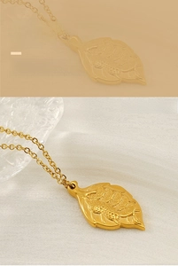 Detailed close-up of a gold leaf necklace pendant featuring embossed traditional coin pattern