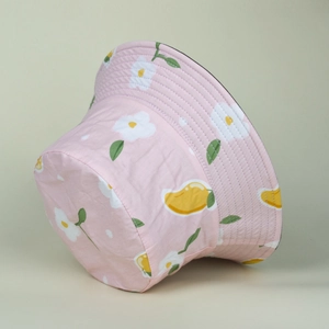 Detailed view of floral bucket hat with white daisy and mango prints on pink cotton fabric