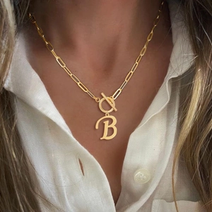 Golden necklace featuring a capital letter B pendant and T-bar toggle clasp on a model