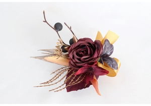 Details von Vintage-Ansteckblume mit burgunderroter Rose, Goldband und Herbstbeeren