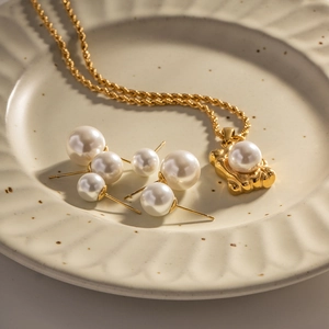French vintage gold jewelry set with large white pearls on a ceramic jewelry tray