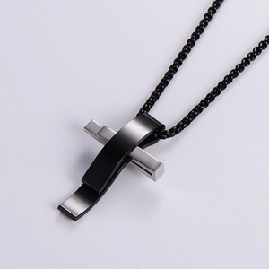 Modern black and silver stainless steel cross pendant necklace on white background