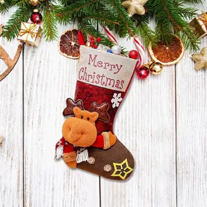 Red Christmas stocking with reindeer plush and Merry Christmas text on wooden background