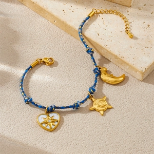Bracelet bohème en coton tressé avec pendentifs lune soleil et cœur sur fond de pierre