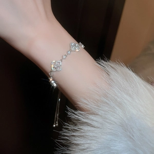 Detailed view of silver clover bracelet with cubic zirconia and adjustable drawstring