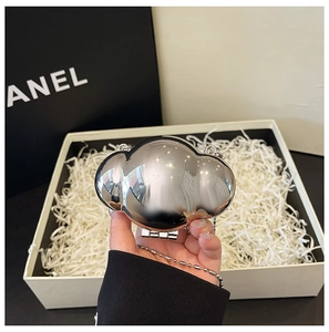 Close-up of a mini silver mirror-finish cloud bag with a delicate metallic bead chain