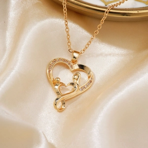 Elegant gold double heart pendant necklace with shimmering crystals on satin background