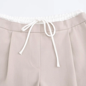 Close-up of khaki wide-leg trousers showing elastic waistband and white drawstrings
