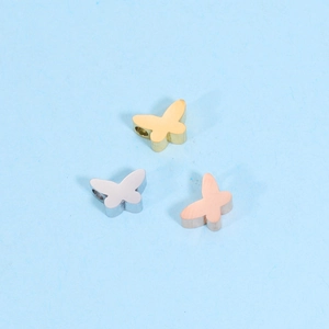 Detailed macro view of butterfly shaped stainless steel loose beads in gold, silver, and rose gold
