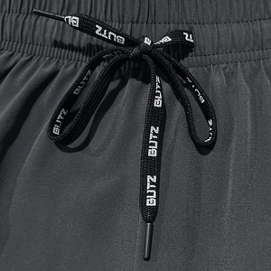 Detail view of black elastic waistband with BUTZ letter printed drawstring on shorts
