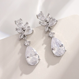 Macro shot of silver drop earrings with pear-cut zircon and marquise-shaped stone settings