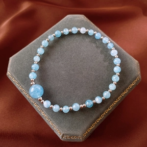Detailed close-up of light blue beaded stone bracelet with polished metal spacer beads
