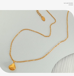 Detailed view of the delicate golden teardrop pendant and refined link chain texture