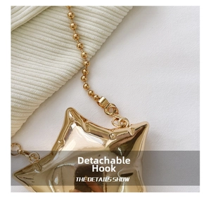 Detail of the detachable gold-plated clasp and bead chain on the star mini bag