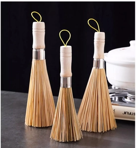 Close-up of three bamboo kitchen brushes with wooden handles and hanging loops