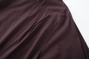 Close-up of shoulder yoke and stitching details on dark cotton poplin shirt