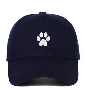 Detail view of white paw print embroidery on a navy blue cotton twill baseball cap