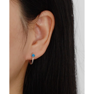 Close-up of minimalist S925 silver hoop earring with blue opal stone inlay on model