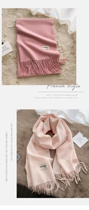 Close-up of soft dusty pink scarf featuring delicate tassels and a woven fabric label