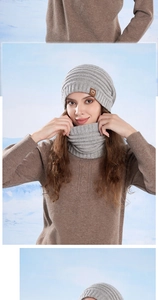 Detail of grey winter knit beanie and neck warmer set with leather logo patch on snow