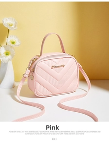 Detail of pink chevron quilted leather small crossbody bag with gold hardware and top handle